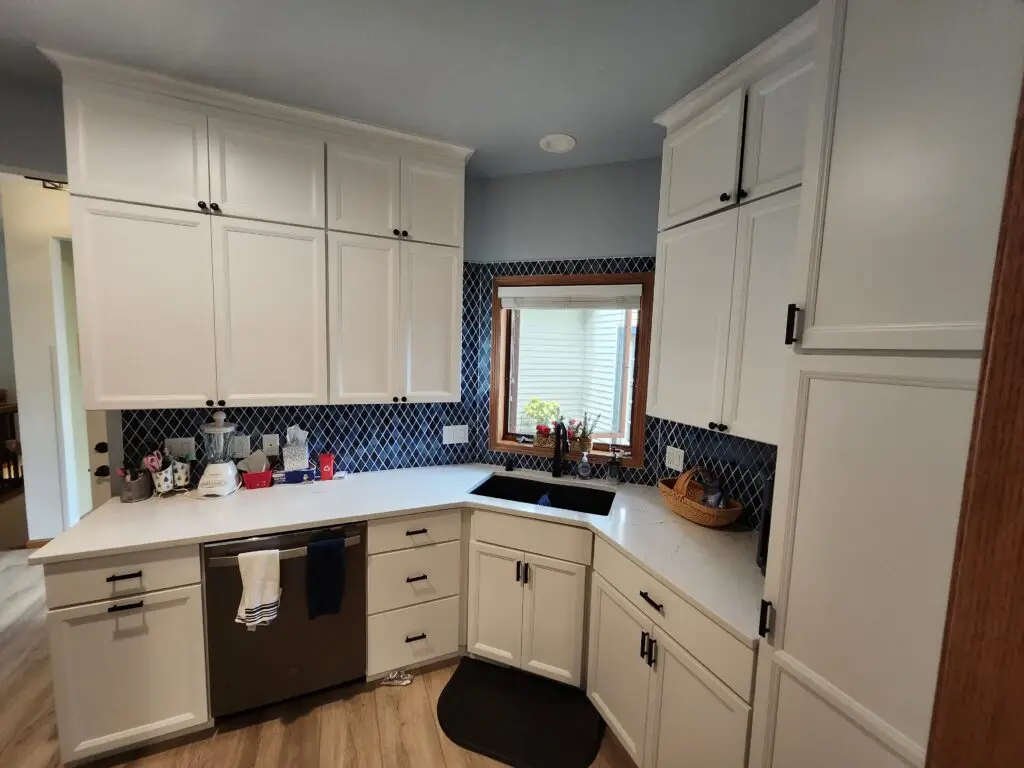 Photograph of a kitchen remodeling done by Adaptive Remodeling Solutions with white cabinets, kitchen counter, and sink.