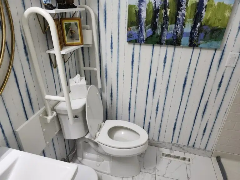 Photograph of a toilet with adjustable arm railings/ grab bar installed by Adaptive Remodeling Solutions.