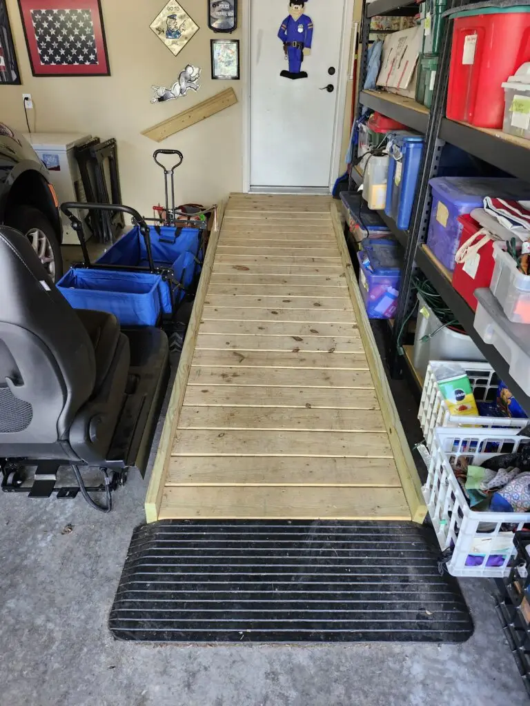 Photograph of a wooden wheelchair ramp and wooden hand rail inside a garage, installed by Adaptive Remodeling Solutions.
