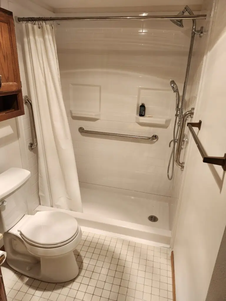 Photograph of a shower installation completed by Adaptive Remodeling Solutions, complete with a grab bar and dual detachable hydro rail shower head system.