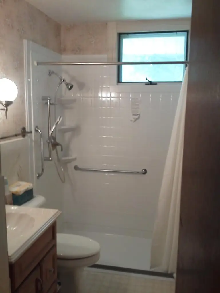 Photograph of a 60x30 shower unit installed by Adaptive Remodeling Solutions, featuring a zero entry shower, hydro rail shower head system, and grab bars.