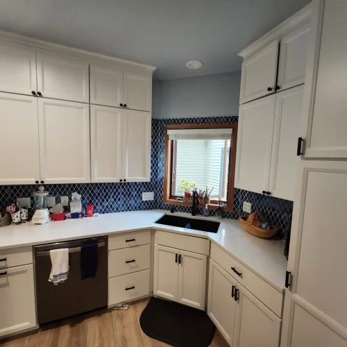 Photograph of a kitchen remodeling done by Adaptive Remodeling Solutions with white cabinets, kitchen counter, and sink.