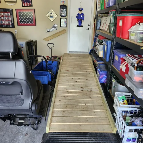 Photograph of a wooden wheelchair ramp and wooden hand rail inside a garage, installed by Adaptive Remodeling Solutions.